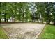 Sandy volleyball court, surrounded by mature trees providing ample shade during a friendly game at 6717 Bickham Ln, Charlotte, NC 28269