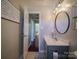 Bathroom features a modern vanity, round mirror, and decorative lighting fixture at 7122 Marlin St, Gastonia, NC 28056