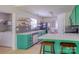 Bright kitchen with green cabinetry, floating shelves, and modern appliances; access to laundry room and dining area at 7122 Marlin St, Gastonia, NC 28056