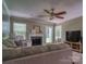 Spacious living room featuring a fireplace, ceiling fan, and a large window at 7122 Marlin St, Gastonia, NC 28056