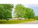 Exterior view of the property featuring lush trees, a carport, and a well-manicured lawn at 745 Rock Castle Dr, York, SC 29745