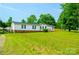 Spacious lawn in front of a single-story home with a covered parking area, complemented by vibrant green grass at 745 Rock Castle Dr, York, SC 29745
