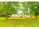 Charming single-story home featuring a lush front yard and a covered parking area, surrounded by mature trees at 745 Rock Castle Dr, York, SC 29745