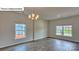 A dining room with hardwood floors, a chandelier and a window with exterior views at 8025 Kennesaw Dr, Gastonia, NC 28056