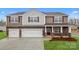 Beautiful two-story home with a three car garage, brick accents, lush lawn, and a covered porch at 8025 Kennesaw Dr, Gastonia, NC 28056