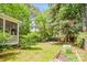 Backyard featuring lush greenery, mature trees, a wooden fence, a charming screened-in porch and a fire pit and garden at 8709 Huntland Ct, Charlotte, NC 28277