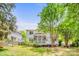 Backyard featuring mature trees, green grass, a play set, a wooden fence, and a charming screened in porch and deck at 8709 Huntland Ct, Charlotte, NC 28277
