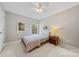 Neutral bedroom with a ceiling fan and window providing natural light at 8709 Huntland Ct, Charlotte, NC 28277