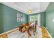 Elegant dining room featuring dark green walls, wood floors, a modern light fixture, and a farmhouse table at 8709 Huntland Ct, Charlotte, NC 28277