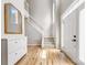 Bright entryway with hardwood floors, white trim, a staircase, and ample natural light from a large window at 8709 Huntland Ct, Charlotte, NC 28277