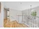 Bright hallway with hardwood floors, white railings, and a decorative chandelier at 8709 Huntland Ct, Charlotte, NC 28277