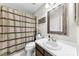 Cozy bathroom featuring a decorative mirror, fresh vanity, and a tub with a neutral-toned shower curtain at 9013 St Croix Ln, Charlotte, NC 28277