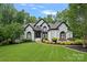 Charming two-story home with a lush green lawn, a dark roof, and beautiful landscaping at 1001 Berwick Ct, Waxhaw, NC 28173