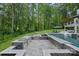 Backyard oasis featuring a luxurious pool, outdoor kitchen, and spacious seating areas surrounded by lush landscaping at 1001 Berwick Ct, Waxhaw, NC 28173