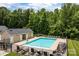 Community pool with lounge chairs, tables, and umbrellas surrounded by a fence and pool house at 112 St Vincent Pl, Mount Holly, NC 28120