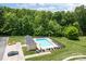 Aerial view of a community pool surrounded by lounge chairs, lush greenery, and a nearby pool house at 112 St Vincent Pl, Mount Holly, NC 28120