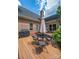 Backyard featuring a brick house, dark roof, a black grill and an umbrella-covered table and chairs at 11724 Brambleton Ct, Charlotte, NC 28277