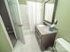 Well-maintained bathroom with green walls, granite countertop, and white tiled floors at 11724 Brambleton Ct, Charlotte, NC 28277