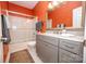 Bathroom with orange walls, granite countertop, modern fixtures, and shower-tub combination at 11724 Brambleton Ct, Charlotte, NC 28277