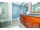 Modern bathroom with double vanity, wood cabinetry, and tiled walk-in shower at 11724 Brambleton Ct, Charlotte, NC 28277