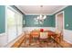 Elegant dining room with hardwood floors, a modern chandelier, and large windows providing ample natural light at 11724 Brambleton Ct, Charlotte, NC 28277