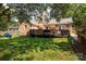 Expansive backyard with lush green grass, mature trees, and a large deck for entertaining at 1208 Chausley Ct, Charlotte, NC 28211