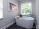 Modern bathroom with a freestanding soaking tub and large window overlooking greenery at 1208 Chausley Ct, Charlotte, NC 28211