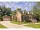 Inviting brick home with detached garage and a well-maintained, lush lawn at 1208 Chausley Ct, Charlotte, NC 28211