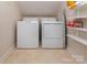 Bright laundry room features a washer, dryer, and shelving for ample storage at 1208 Chausley Ct, Charlotte, NC 28211