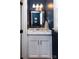 Elegant powder room featuring a marble countertop, white cabinets, and stylish fixtures at 1208 Chausley Ct, Charlotte, NC 28211