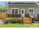 Wooden back deck with wooden rails and stairs leading to the yard and a barbecue grill at 1241 Rollins Ave, Charlotte, NC 28205