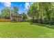 Spacious backyard with lush green grass and mature trees offering shade at 1241 Rollins Ave, Charlotte, NC 28205