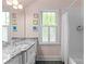 Updated bathroom with marble counters, new fixtures, and white subway tile at 1241 Rollins Ave, Charlotte, NC 28205