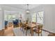 Bright dining room with wood table, modern lighting, and view into living room with fireplace at 1241 Rollins Ave, Charlotte, NC 28205