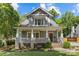 Charming two-story home featuring a welcoming front porch, beautifully landscaped yard, and classic architectural details at 1241 Rollins Ave, Charlotte, NC 28205