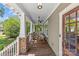 Relaxing covered front porch featuring ceiling fans, rocking chairs, and lovely views of the surrounding neighborhood at 1241 Rollins Ave, Charlotte, NC 28205