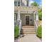 Inviting front porch with wood steps, white railing and columns, plus a stylish wooden door and well-maintained landscaping at 1241 Rollins Ave, Charlotte, NC 28205