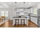 Kitchen island features seating and modern pendant lighting above granite countertop and white cabinetry at 1241 Rollins Ave, Charlotte, NC 28205