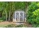 A wooden shed sits surrounded by lush greenery, offering ample storage space in a serene setting at 1241 Rollins Ave, Charlotte, NC 28205