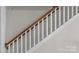 A bright staircase features white spindles and stained wood handrail at 1241 Rollins Ave, Charlotte, NC 28205