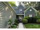 Welcoming home exterior featuring red shutters, lush landscaping, and a charming walkway leading to the front door at 12610 Angel Oak Dr, Huntersville, NC 28078