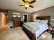 This main bedroom features a ceiling fan, dark colored furniture, and warm colored walls at 12610 Angel Oak Dr, Huntersville, NC 28078
