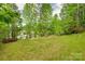 Serene backyard featuring lush greenery and a gentle slope at 12719 Vantage Point Ln, Huntersville, NC 28078