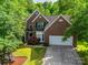 Charming brick home featuring a well-manicured lawn and a two-car garage, nestled among lush green trees at 12719 Vantage Point Ln, Huntersville, NC 28078