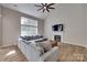 Living room featuring high ceilings, large windows, cozy fireplace, modern ceiling fan, and comfortable seating area at 12719 Vantage Point Ln, Huntersville, NC 28078
