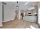 Spacious living area open to kitchen, showcasing modern lighting and natural light from large windows, plus wood flooring at 12719 Vantage Point Ln, Huntersville, NC 28078
