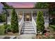 Charming home featuring a welcoming front porch with white railings, gray siding, and manicured landscaping at 131 Swink Sw St, Concord, NC 28027