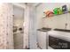 Convenient laundry area featuring a washer, dryer, and shelving for storage, with a view into an adjacent room at 131 Swink Sw St, Concord, NC 28027