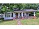 Charming home featuring a cozy front porch with brick support pillars, perfect for enjoying the outdoors at 1313 Maiden E Rd, Maiden, NC 28650