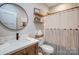 This bathroom has a toilet, shower with white curtain and shelves and a decorative mirror on the wall at 141 Ole Eastpointe Dr, York, SC 29745
